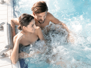Eine Frau und ein Mann im Pool im Thermen- & Vulkanland